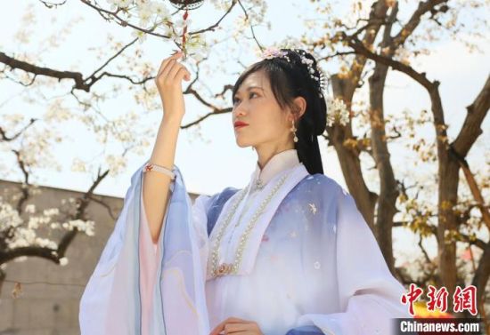 圖為蘭州青年身穿漢服在百年梨園賞景?！「哒?攝