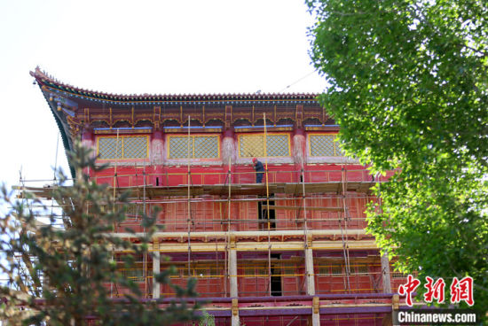 圖為5月上旬，甘肅山丹縣大佛寺內(nèi)，工作人員對(duì)古建筑大雄寶殿進(jìn)行修繕。 中新社記者 高展 攝