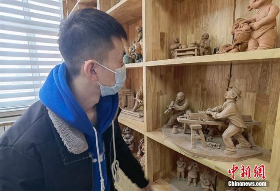 圖為學(xué)生欣賞泥塑作品。 劉玉桃 攝