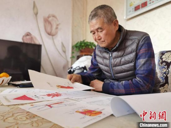 圖為陸鵬飛向記者展示多年帶隊(duì)的手寫(xiě)筆記?！堟?攝