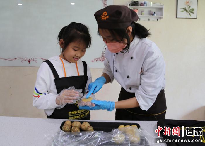 圖為在甘臺(tái)胞小朋友在工作人員指導(dǎo)下制作月餅。九美旦增 攝