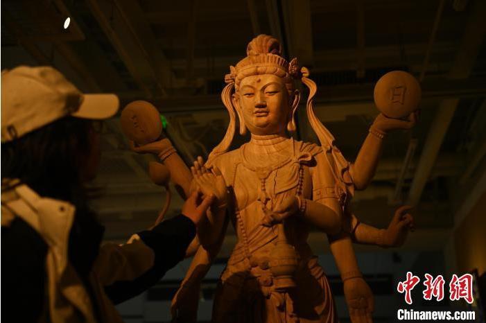 圖為季茂杰觀察自己創(chuàng)作的敦煌木雕。李亞龍 攝</p>
<p>