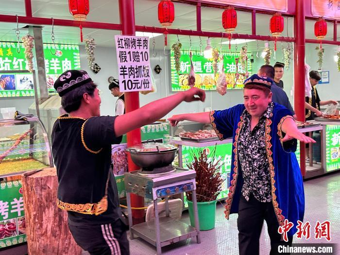 圖為餐飲經(jīng)營者在“西涼不夜城”跳起舞蹈引客?！〈魑牟?攝</p><p>